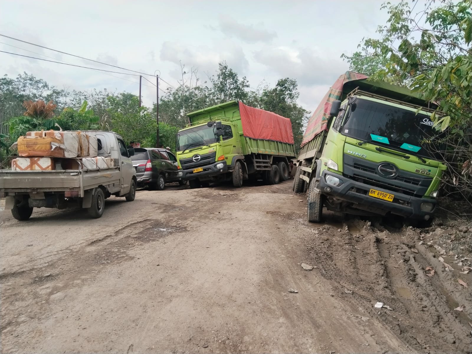 Terlihat dua truk batu bara terperosok