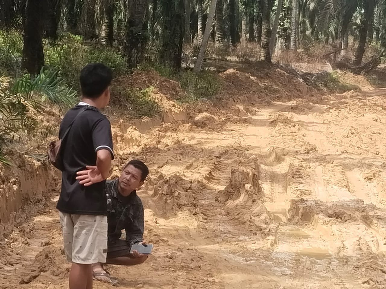 Terlihat warga melihat kondisi jalan yang rusak parah (
