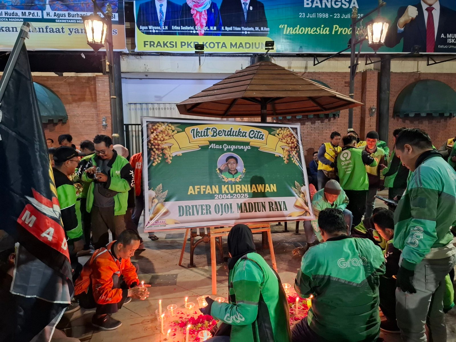 Karangan bunga dipenuhi lilin seabgai wujud aksi solidaritas ojol sekota Madiun (Foto: Zack,NewsTujuh)