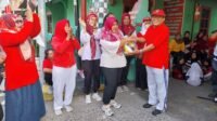 Tokoh masyarakat Sutardi ketika menyerahkan hadiah doorprize kepada warga yang ikuti jalan sehat (Foto : Bas,NewsTujuh)