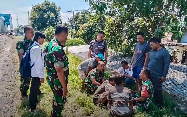 Nyaris Jadi Korban, Mahasiswa Diduga Depresi Dievakuasi dari Rel KA Jembatan Beteng Madiun 2 Warga dan petugas menenangkan RRM, mahasiswa ITS Surabaya, setelah dievakuasi dari jalur kereta. (Her, NewsTujuh)